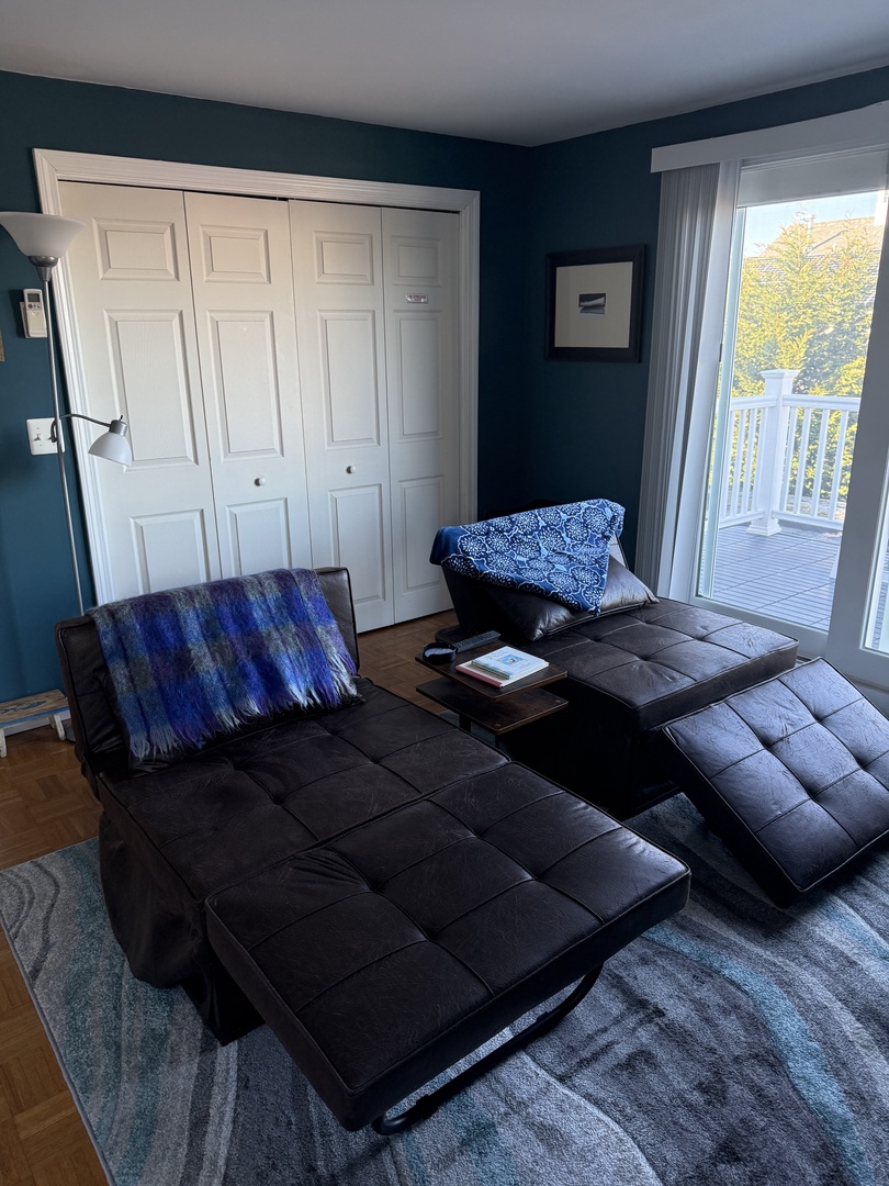 Settle into your stylish living space with plush seating and vibrant teal walls that create a welcoming atmosphere for relaxation.