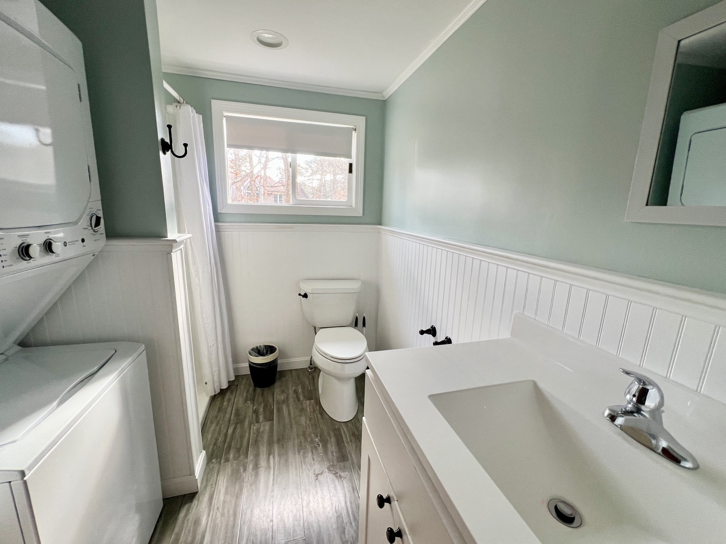 Step into your refreshing bathroom with crisp mint walls, charming wainscoting, and convenient in-unit laundry—everything you need for a comfortable stay.