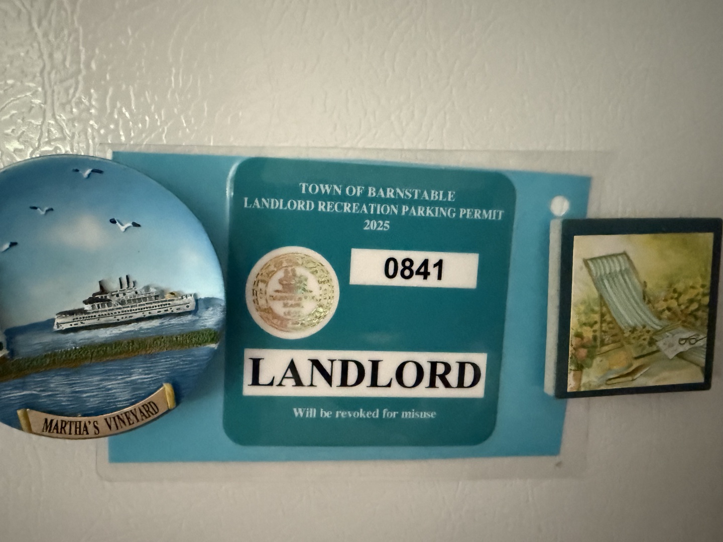 The property holds valid landlord recreation parking permits from the Town of Barnstable for 2025, displayed alongside coastal-themed wall decorations.
