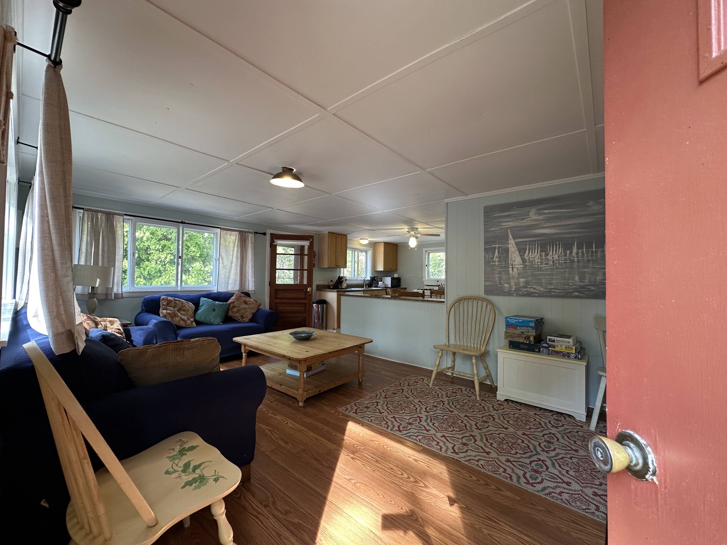 Relax in your bright, open living space with navy sofas and garden views streaming through large windows.