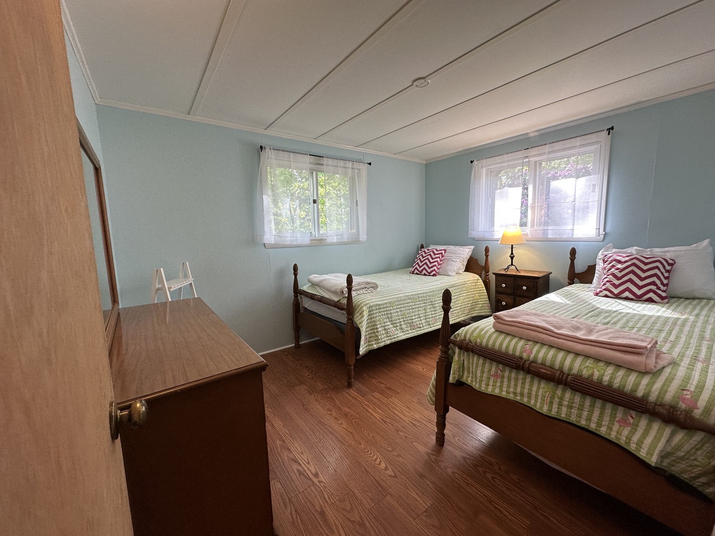 Two comfortable twin beds await you in this cheerful bedroom, where soft blue walls and natural light create the perfect peaceful retreat.