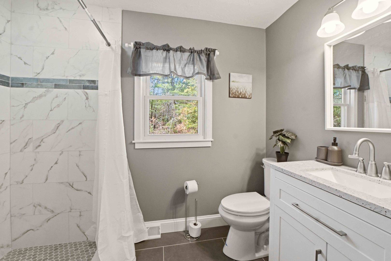 Step into your elegant bathroom featuring marble-inspired shower tiles and modern fixtures, perfect for refreshing after your adventures.