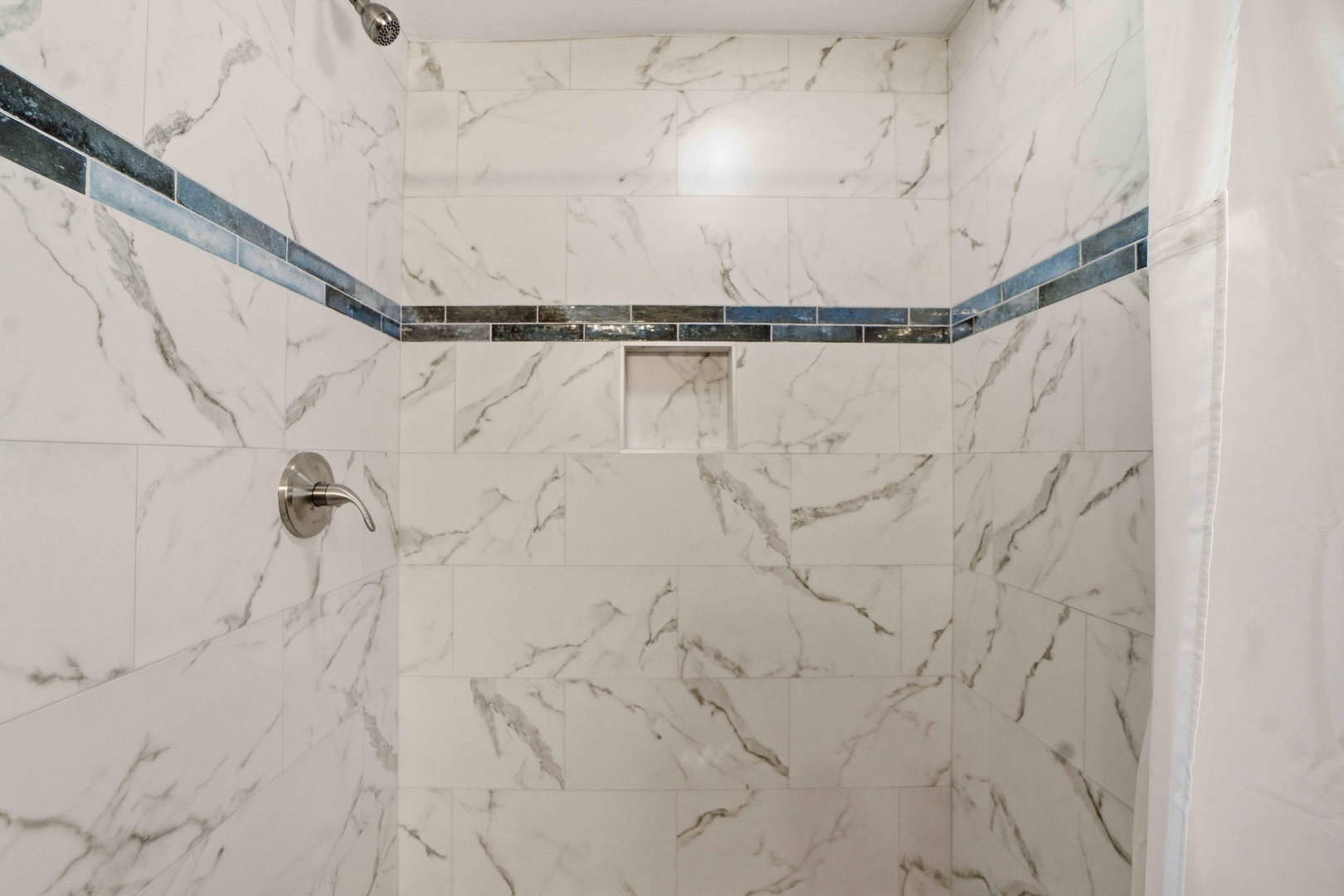 Step into your luxurious marble shower with elegant tile accents and modern fixtures for a spa-like experience.