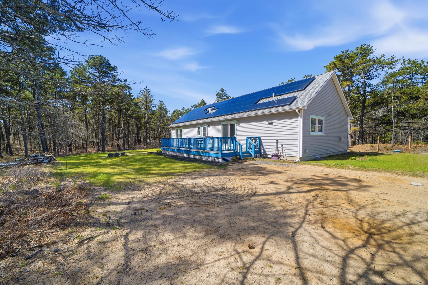 Modern vacation home nestled in peaceful wooded setting with blue deck and private outdoor space for relaxation.