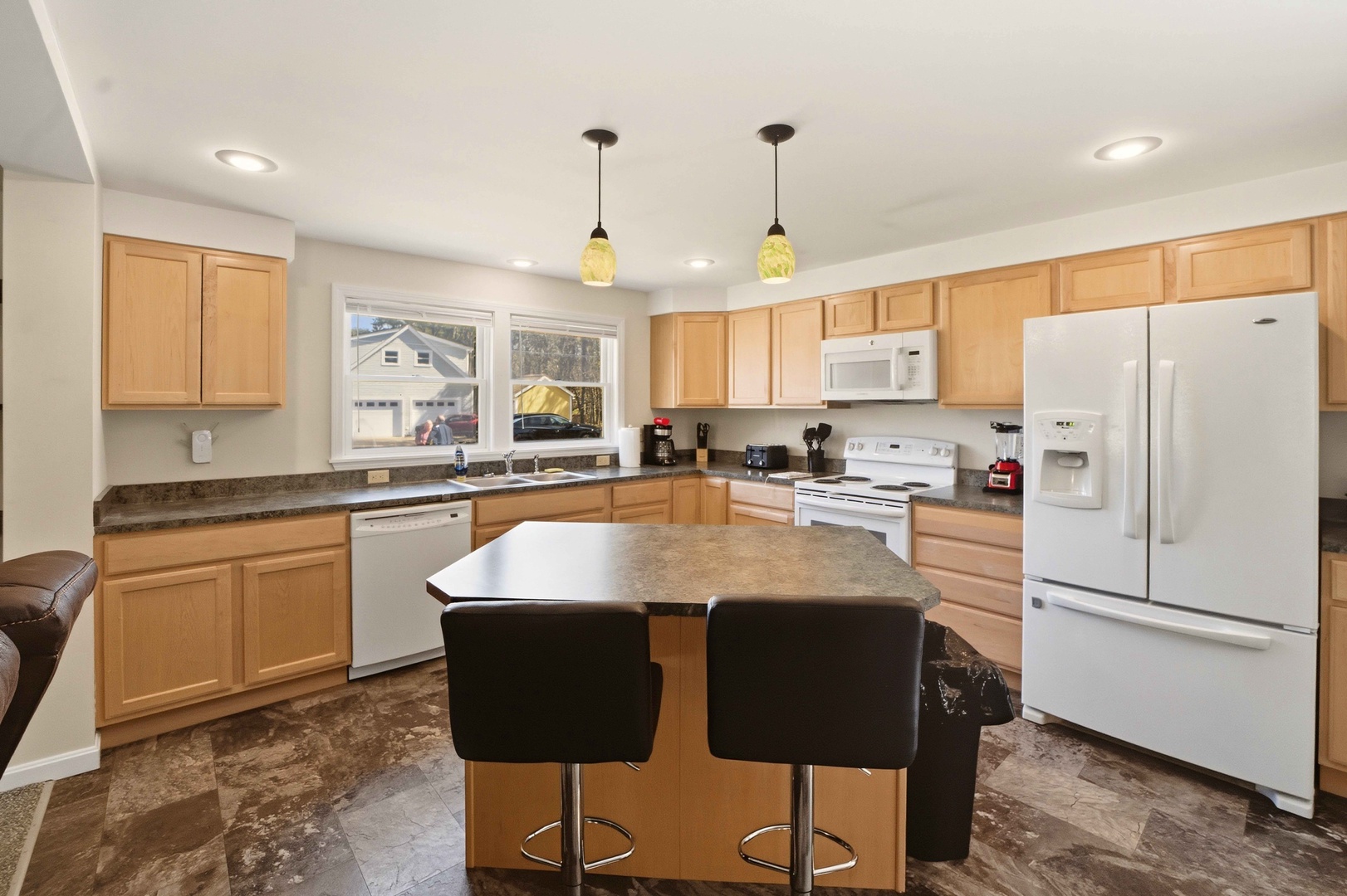 Cook your favorite meals in this spacious, fully-equipped kitchen with granite counters, modern appliances, and a convenient breakfast bar.
