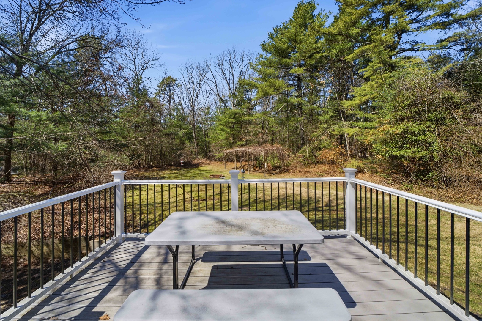 Enjoy peaceful outdoor dining on your private deck overlooking the wooded backyard with fire pit.