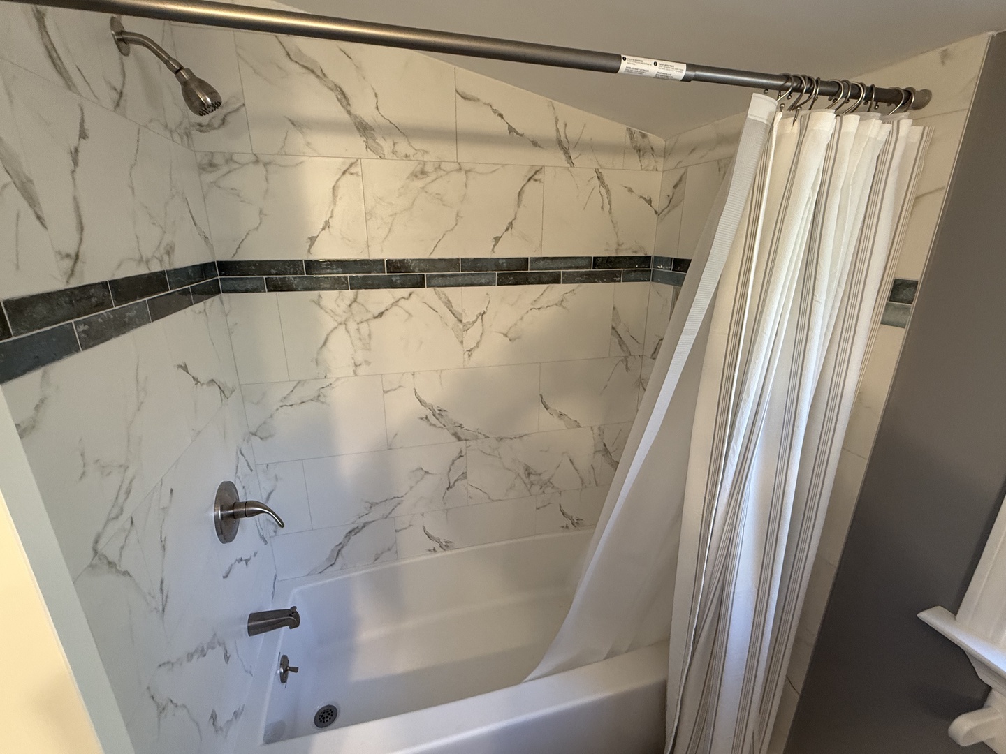 Step into your elegant marble-look shower with rainfall head and deep soaking tub for luxurious relaxation.