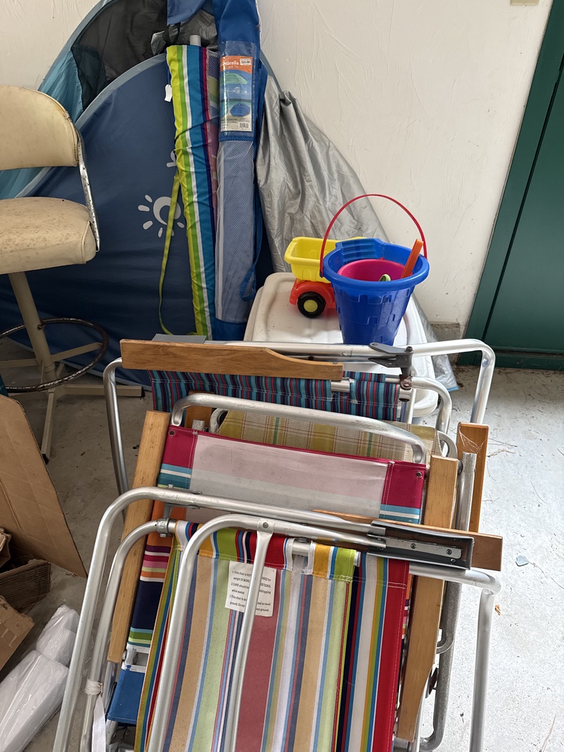 Your vacation home provides practical storage and outdoor essentials, including colorful beach chairs, a folding lounger, and kids' beach toys—everything you need for fun-filled days by the water.