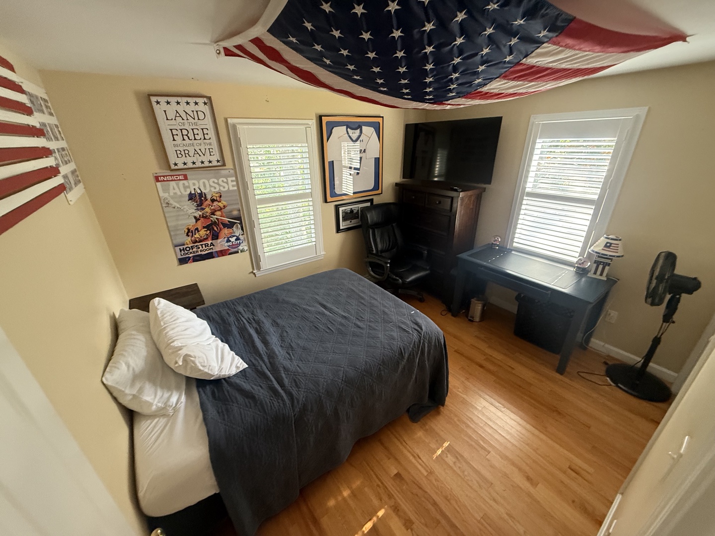 Rest easy in your patriotic retreat with comfortable bedding, entertainment center, and warm morning light streaming through your windows.