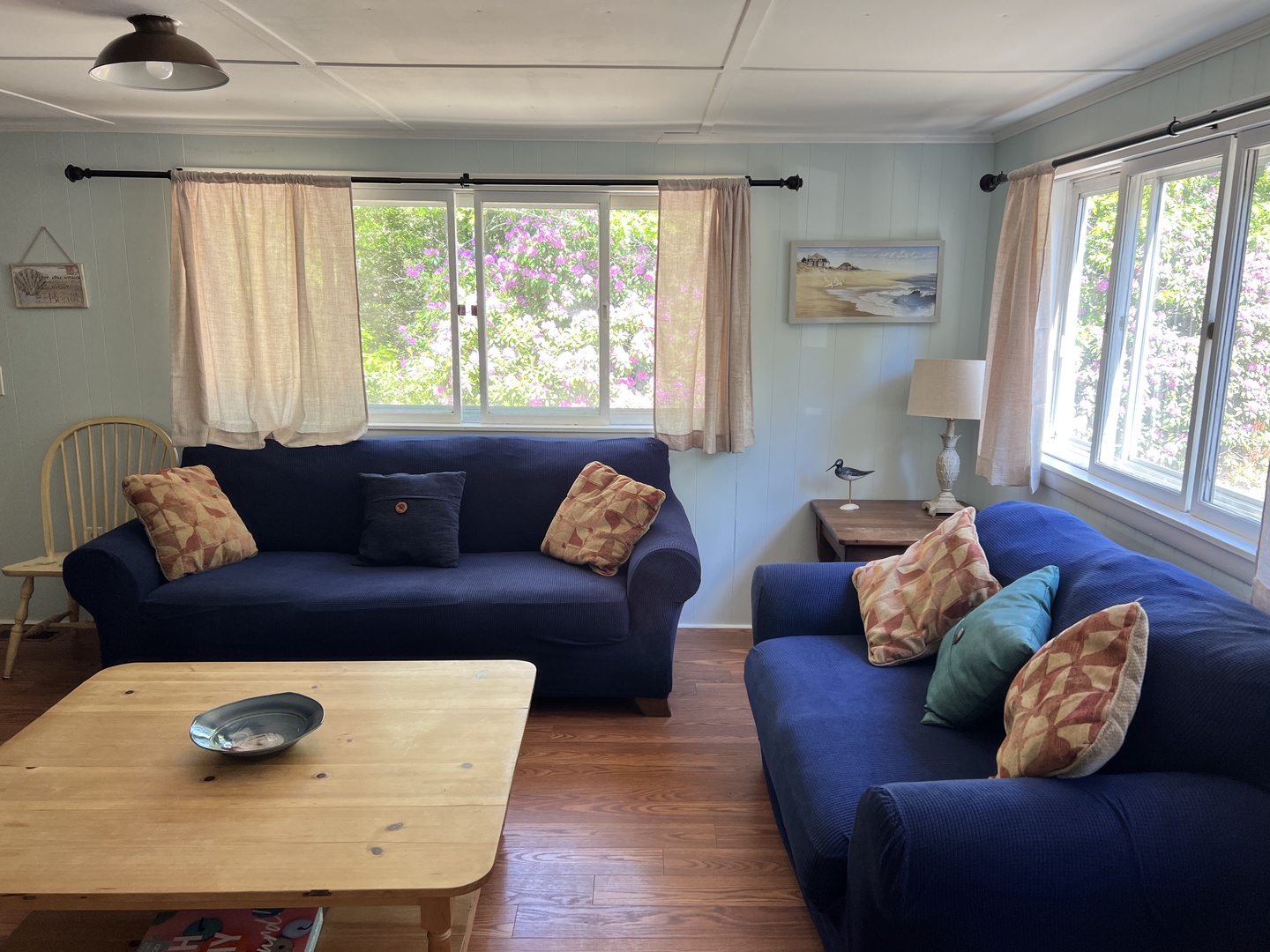 Sink into navy sofas while garden views fill your windows with natural light and blooming colors.
