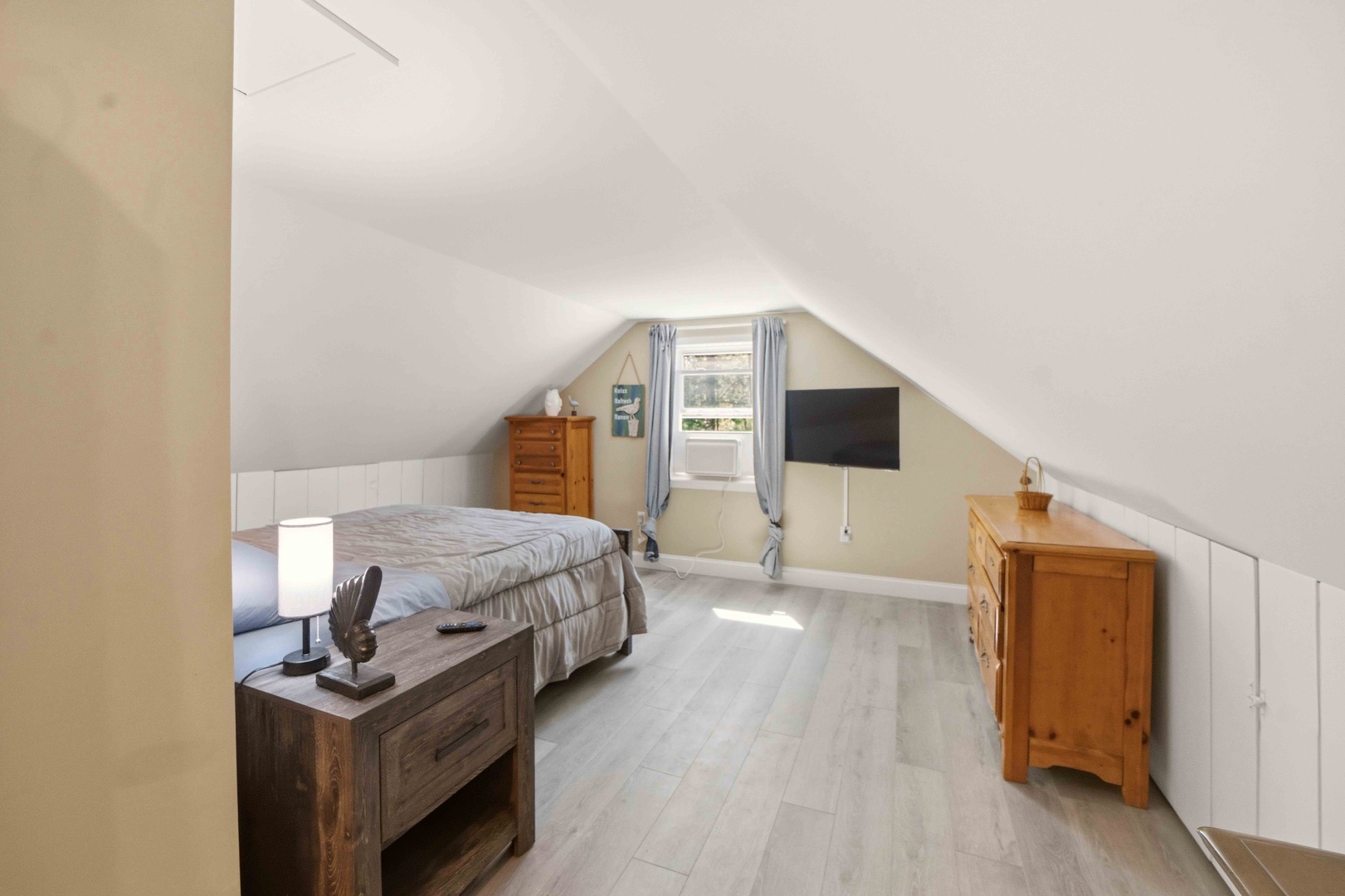 Cozy attic bedroom with slanted ceilings and natural light streaming through your window, creating a peaceful retreat.