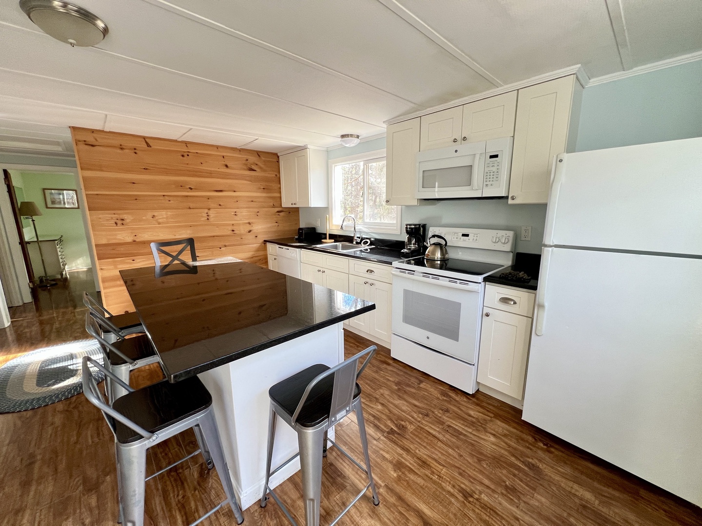 Your fully equipped kitchen features modern appliances and a breakfast bar where you can enjoy morning coffee while planning your day's adventures.