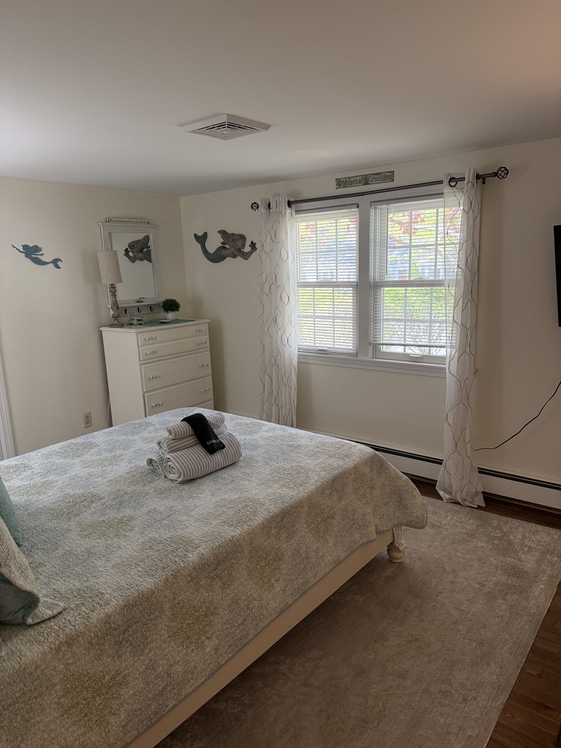 Relax on plush seating with natural light streaming through large windows, creating your serene retreat. Fresh towels and playful decor add comfort to your stay.