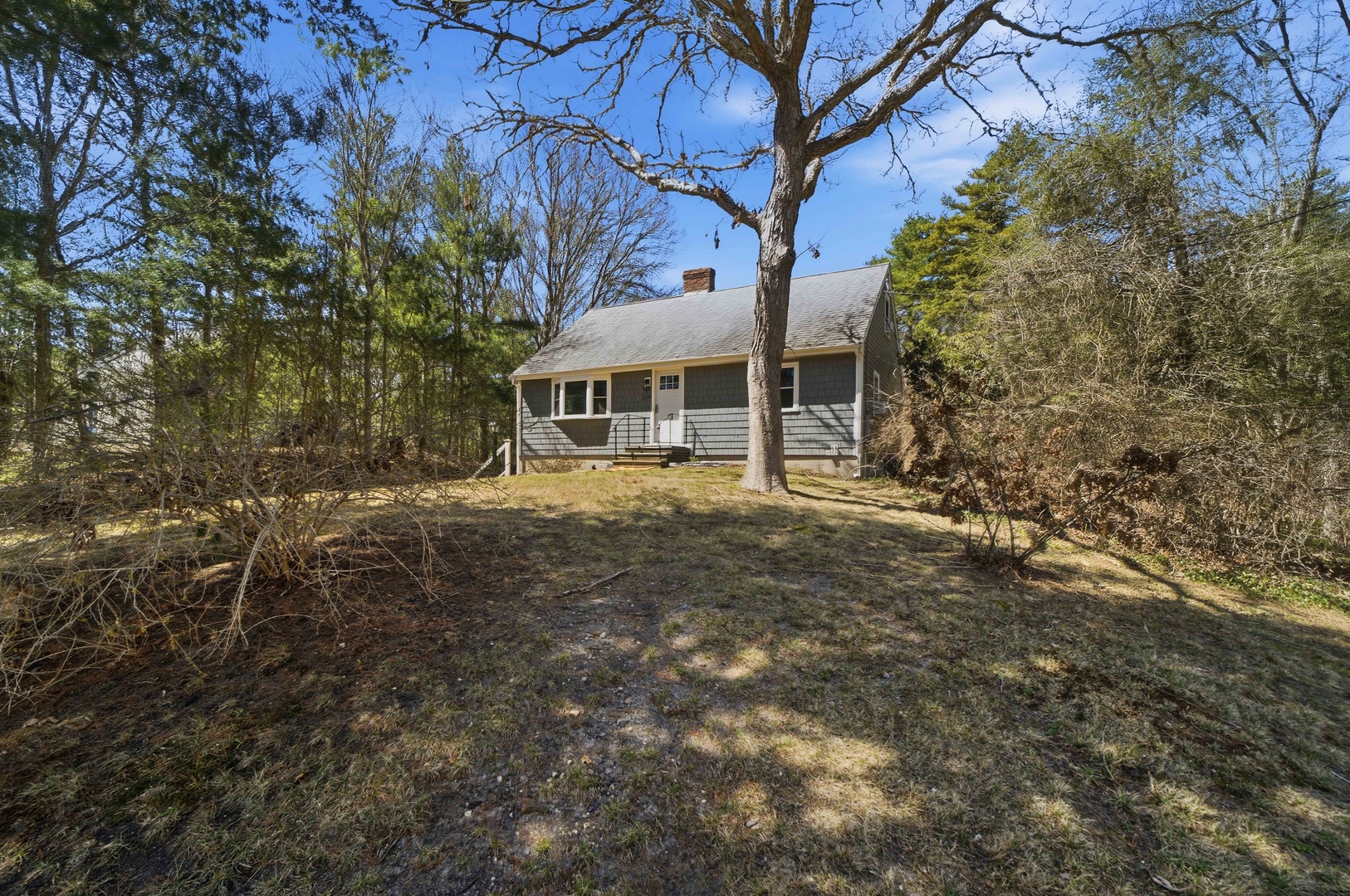 Charming single-story home nestled among mature trees on a private wooded lot, offering peaceful seclusion and natural beauty.