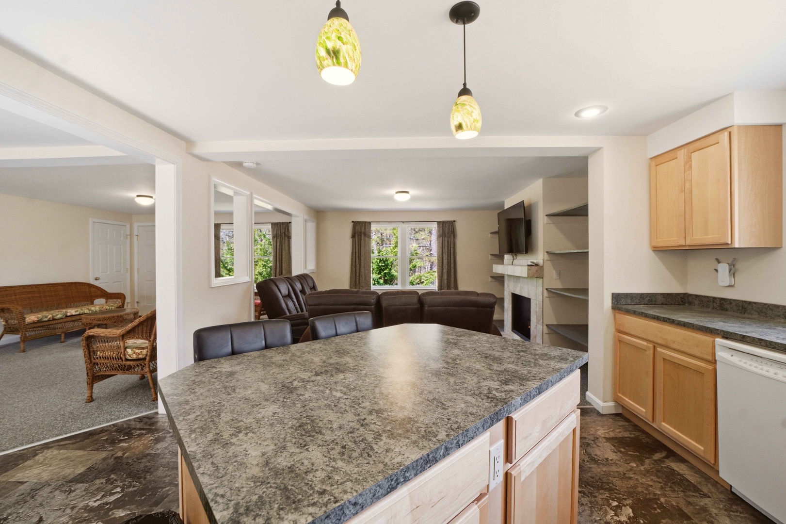 Relax in your spacious open-plan retreat with granite counters, cozy fireplace, and beautiful pendant lighting creating the perfect atmosphere for your getaway.