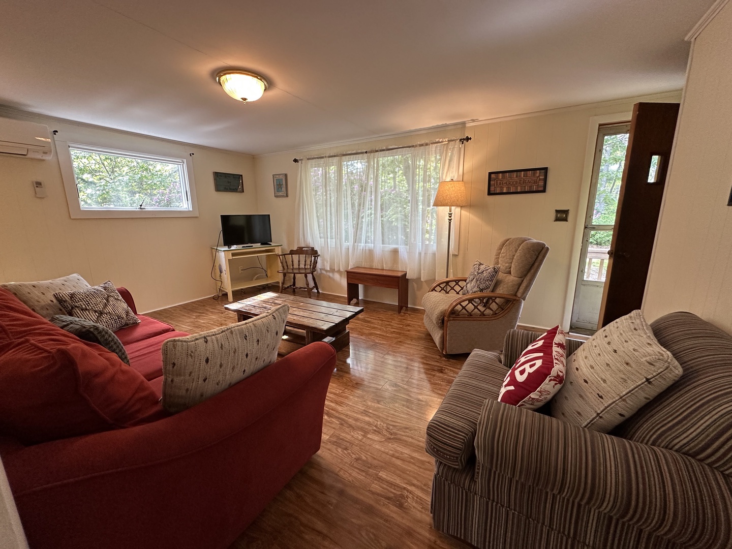 Unwind in your cozy living room with comfortable seating for everyone, natural light streaming through large windows, and entertainment ready for relaxing evenings together.