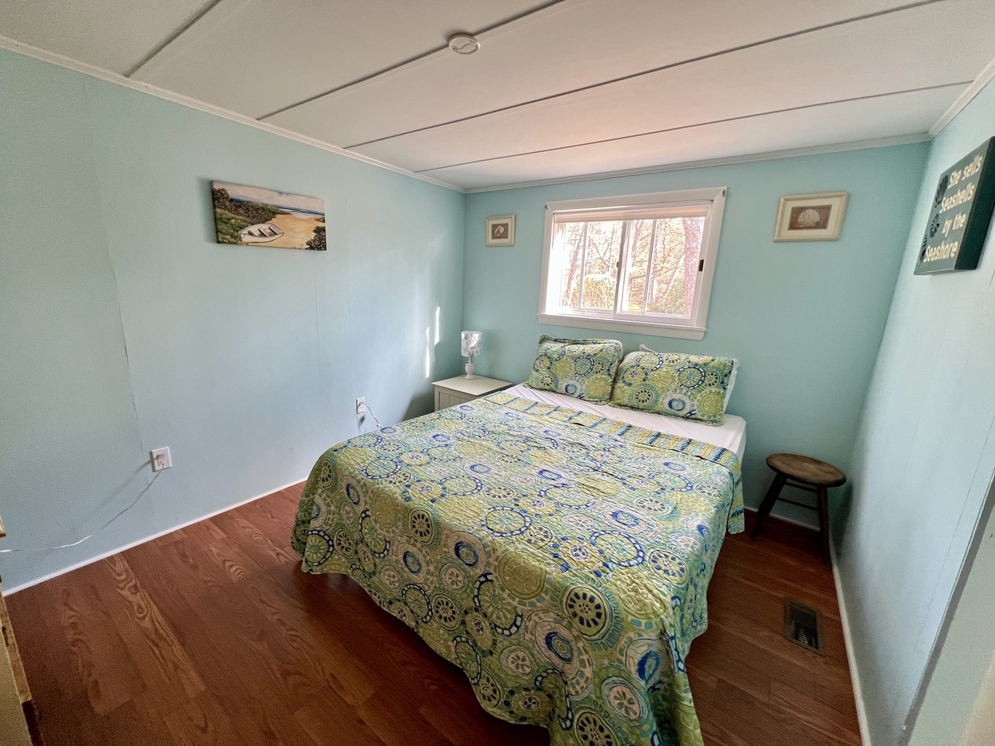 Drift off to sleep in your peaceful bedroom, where soft blue walls and charming artwork create a tranquil retreat.