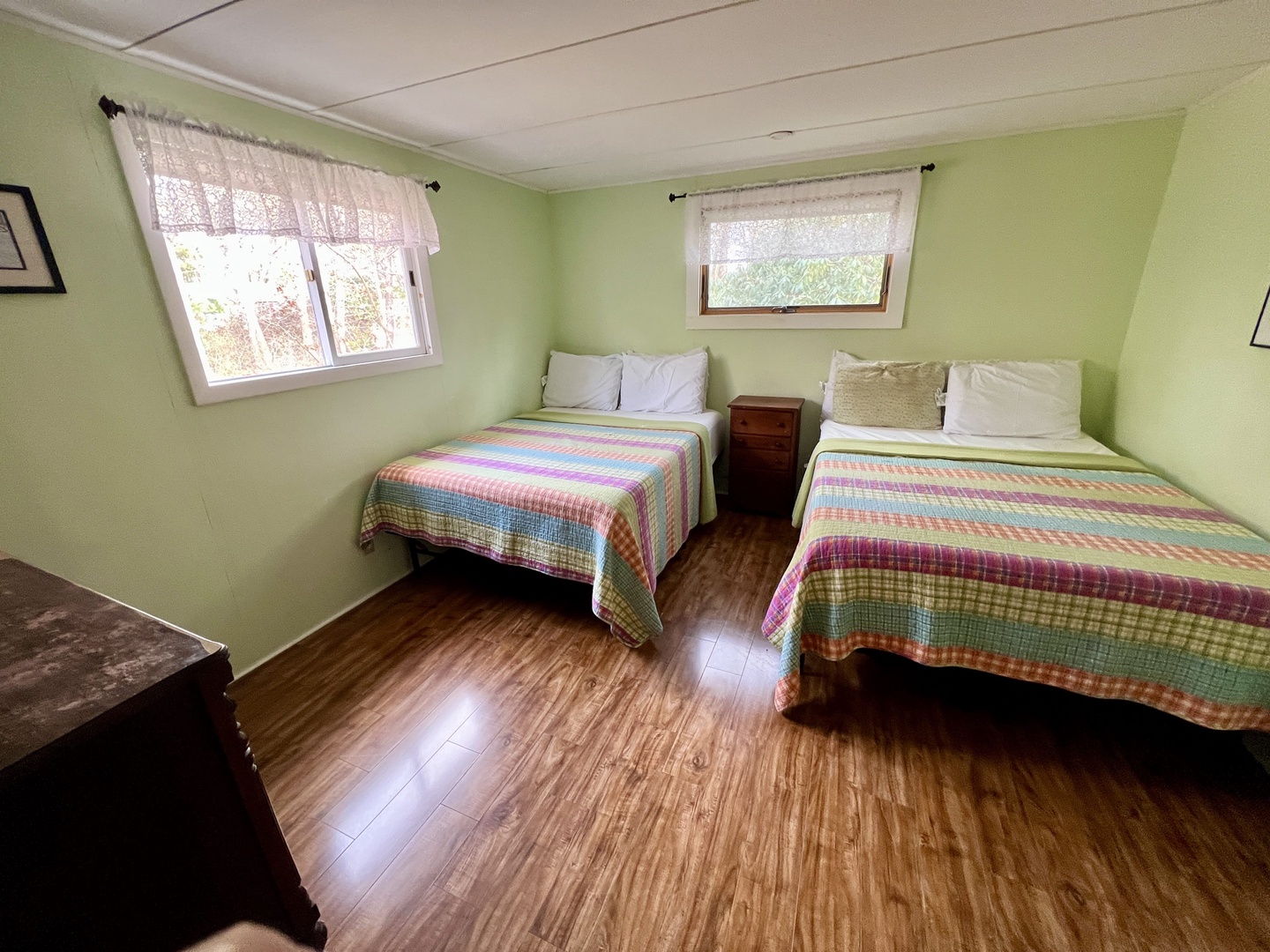 Rest peacefully in your bright twin bedroom with colorful quilts, natural light, and garden views.