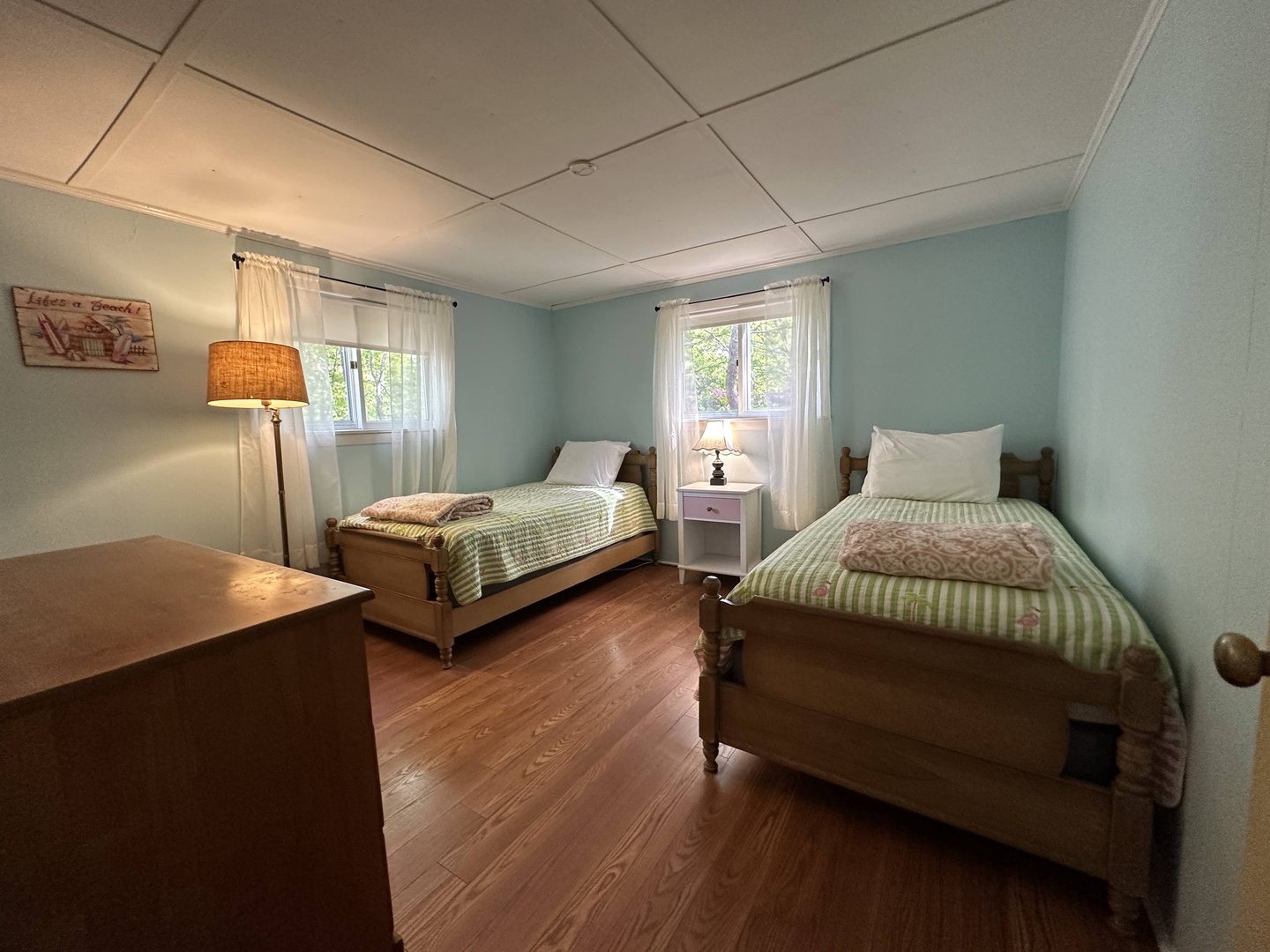 Your peaceful twin bedroom features warm hardwood floors and soft lighting, perfect for restful nights after exploring.