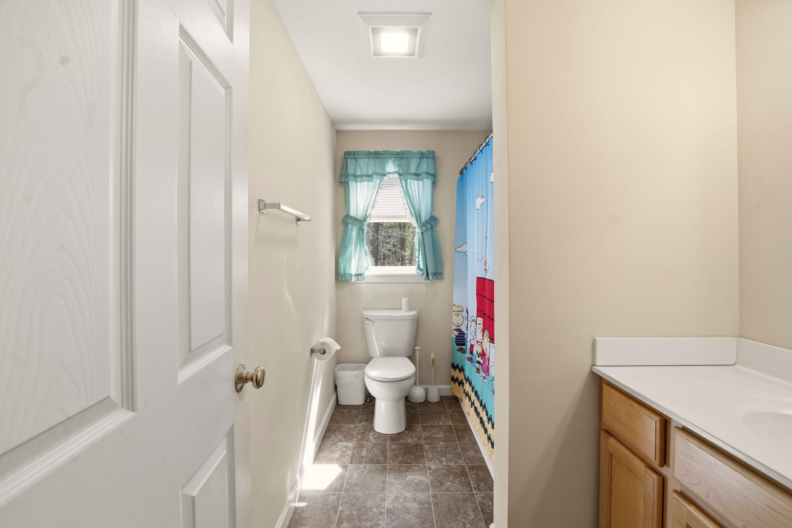 Step into your private bathroom featuring natural light from charming windows and cheerful nautical touches that make your morning routine delightful.