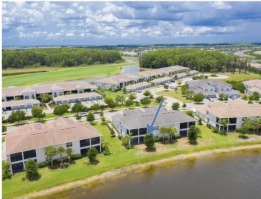 Aerial view of a peaceful vacation community overlooking a pristine golf course and tranquil water features, nestled in lush Florida surroundings.