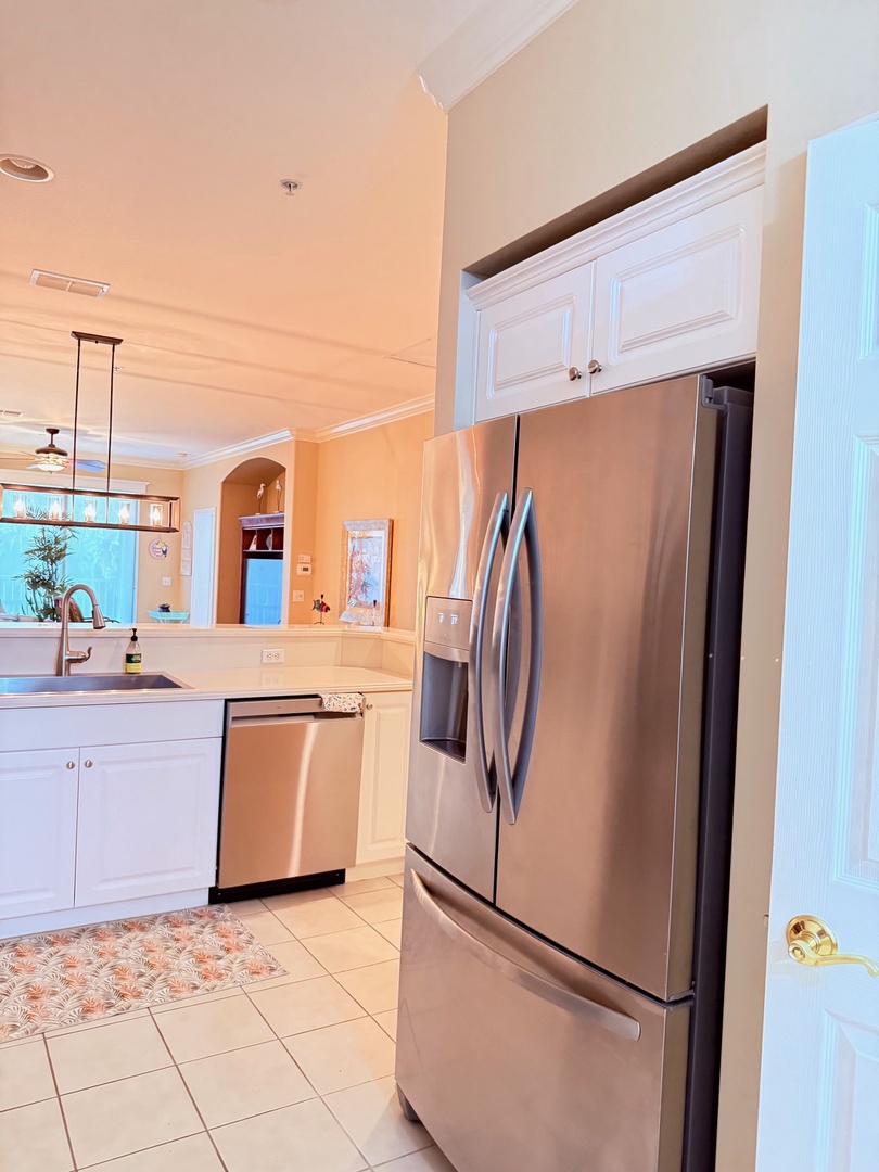 Your fully equipped kitchen features stainless steel appliances and a sleek glass cooktop—perfect for preparing meals at your leisure in this inviting open space.
