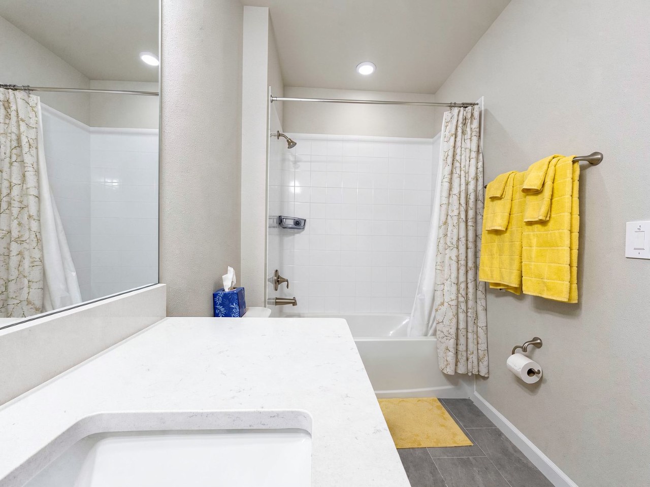 Bright and spotlessly clean, your private bathroom offers a refreshing tub-shower combo, plush towels in cheerful yellow, and plenty of counter space for all your essentials.