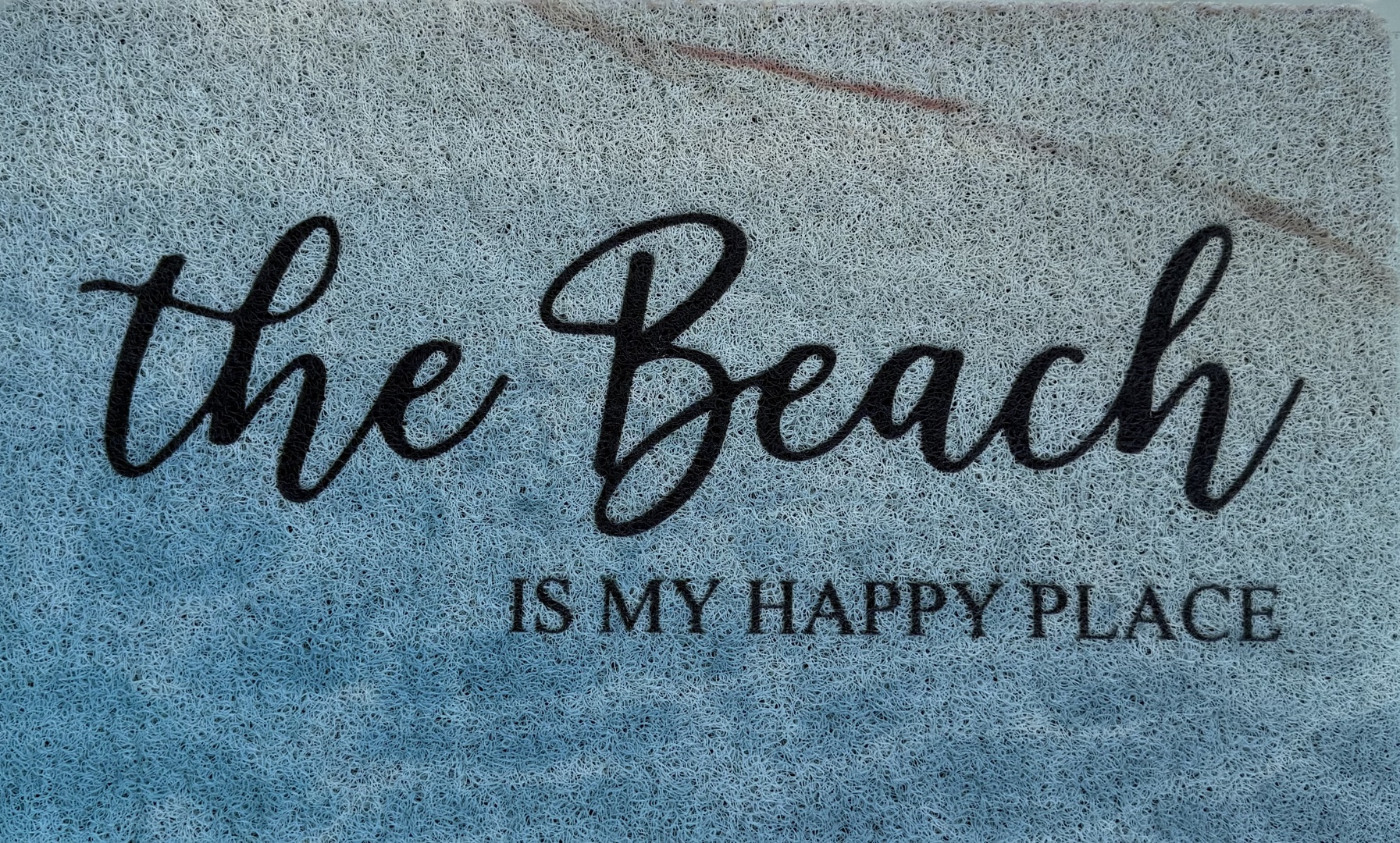 A cheerful beach-themed welcome mat sets the perfect coastal mood as you arrive at your oceanside retreat.