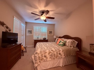 Your cozy bedroom features a plush queen bed, ceiling fan, and warm lighting—perfect for unwinding after a day of adventure. Soft linens and bedside lamps create a welcoming retreat.