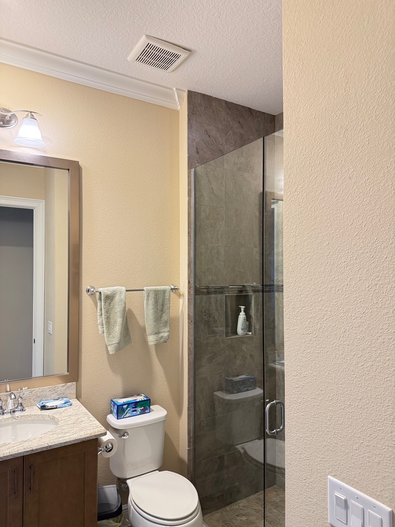 Third bathroom Step into your pristine glass-enclosed shower with rainfall showerhead and elegant stone finishes for a luxurious start to your day.