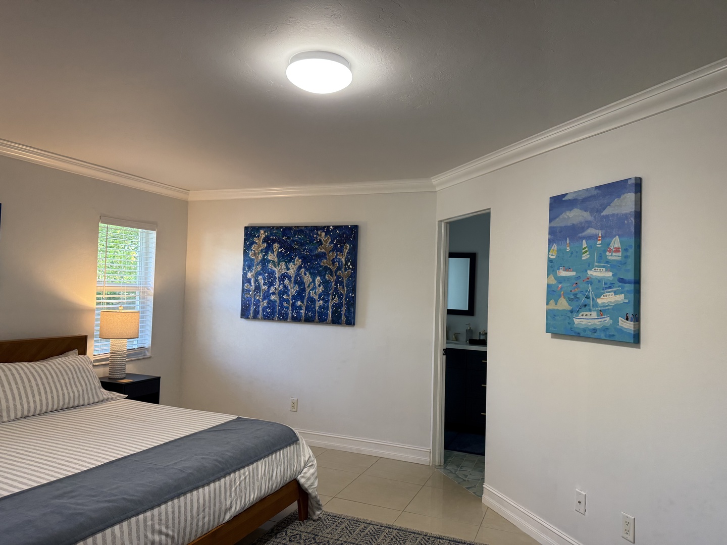 Drift off in your serene king bedroom featuring coastal artwork and clean lines, with your private bathroom just steps away.