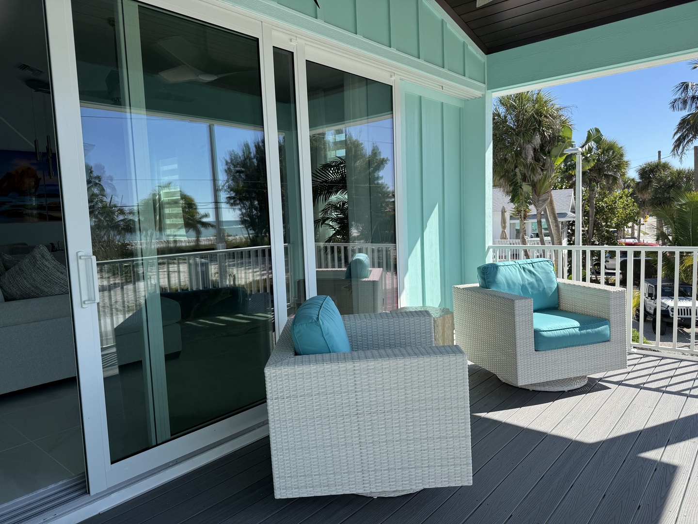 Relax on your private balcony with comfortable wicker seating and turquoise cushions, perfect for morning coffee or sunset drinks.