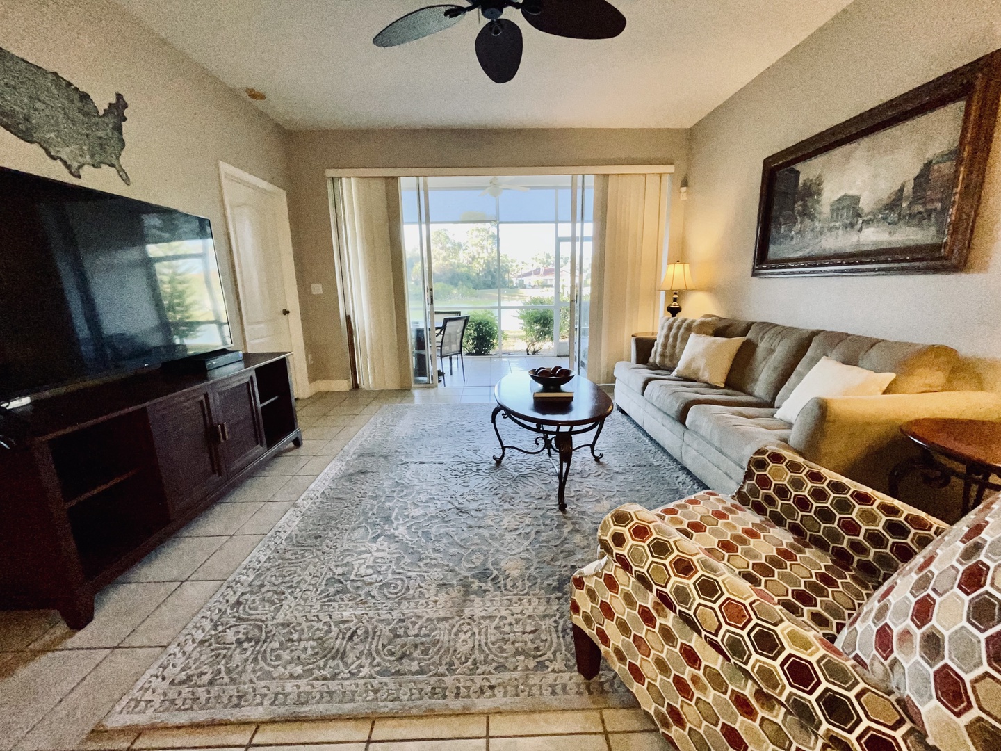Unwind in your spacious living room with plush seating, large TV, and patio doors opening to peaceful views.