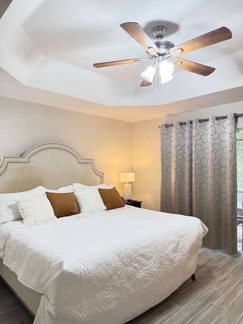 Main Bedroom King Sleep number bed. Relax in your elegant bedroom featuring a plush king bed, soothing neutral tones, and gentle ceiling fan for perfect comfort.