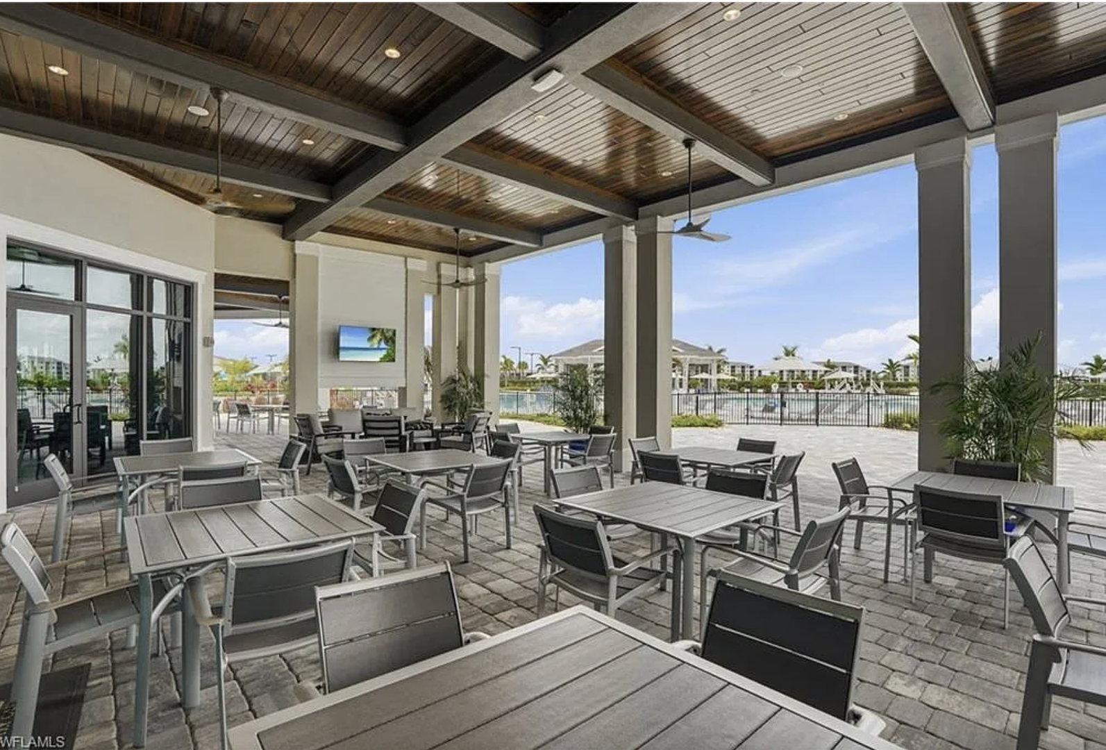 Gather with friends at this covered outdoor dining area with modern seating, ceiling fans, and a relaxed resort atmosphere.