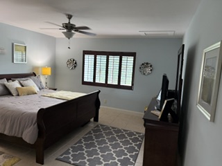 Step into your tranquil retreat—a cozy bedroom where you'll unwind under the gentle breeze of the ceiling fan and rest easy on the inviting bed, wrapped in soft linens and the calming ambiance.