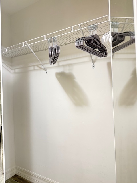 Main bedroom closet 1 Your spacious walk-in closet features wire shelving and hangers, providing ample storage space for all your belongings during your stay.