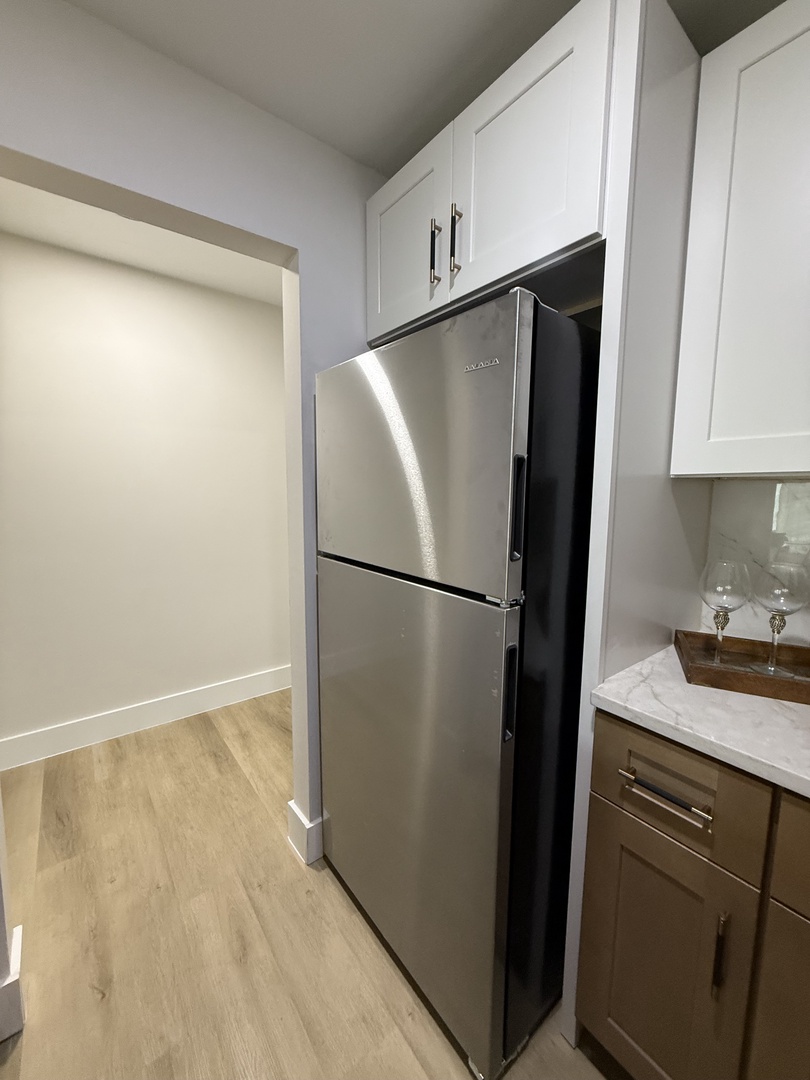 Your sleek kitchen features stainless steel appliances and bright white cabinetry, creating the perfect space for preparing meals during your stay.
