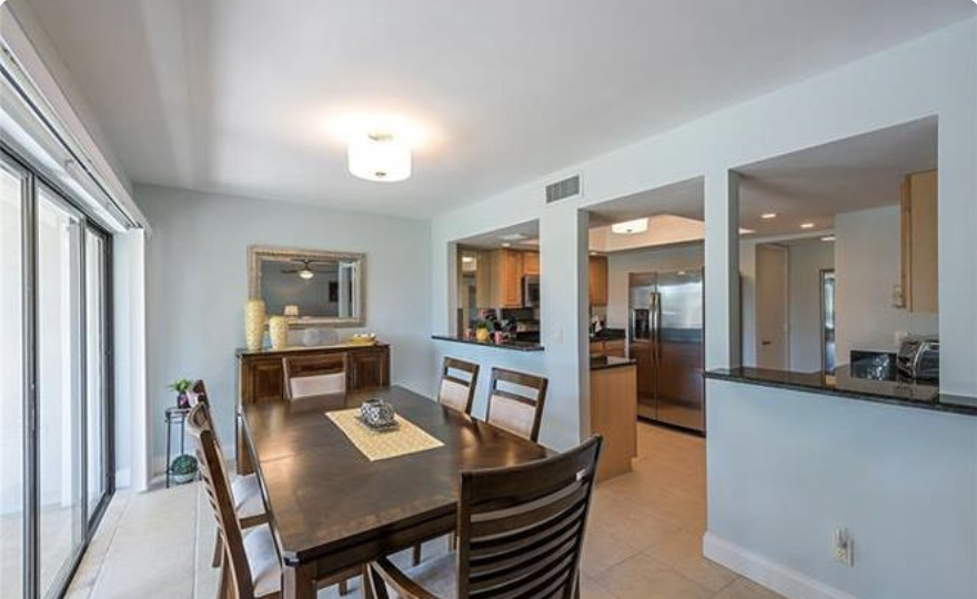 Step into your open-concept living space where the dining area flows seamlessly into a fully equipped kitchen, perfect for gathering over meals and making vacation memories together.