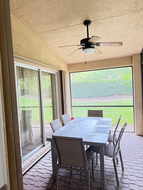 Savor meals with your loved ones in this elegant screened dining area, where ceiling fans keep you cool while you enjoy garden views through screened in porch, sliders to main bedroom and door to private back yard