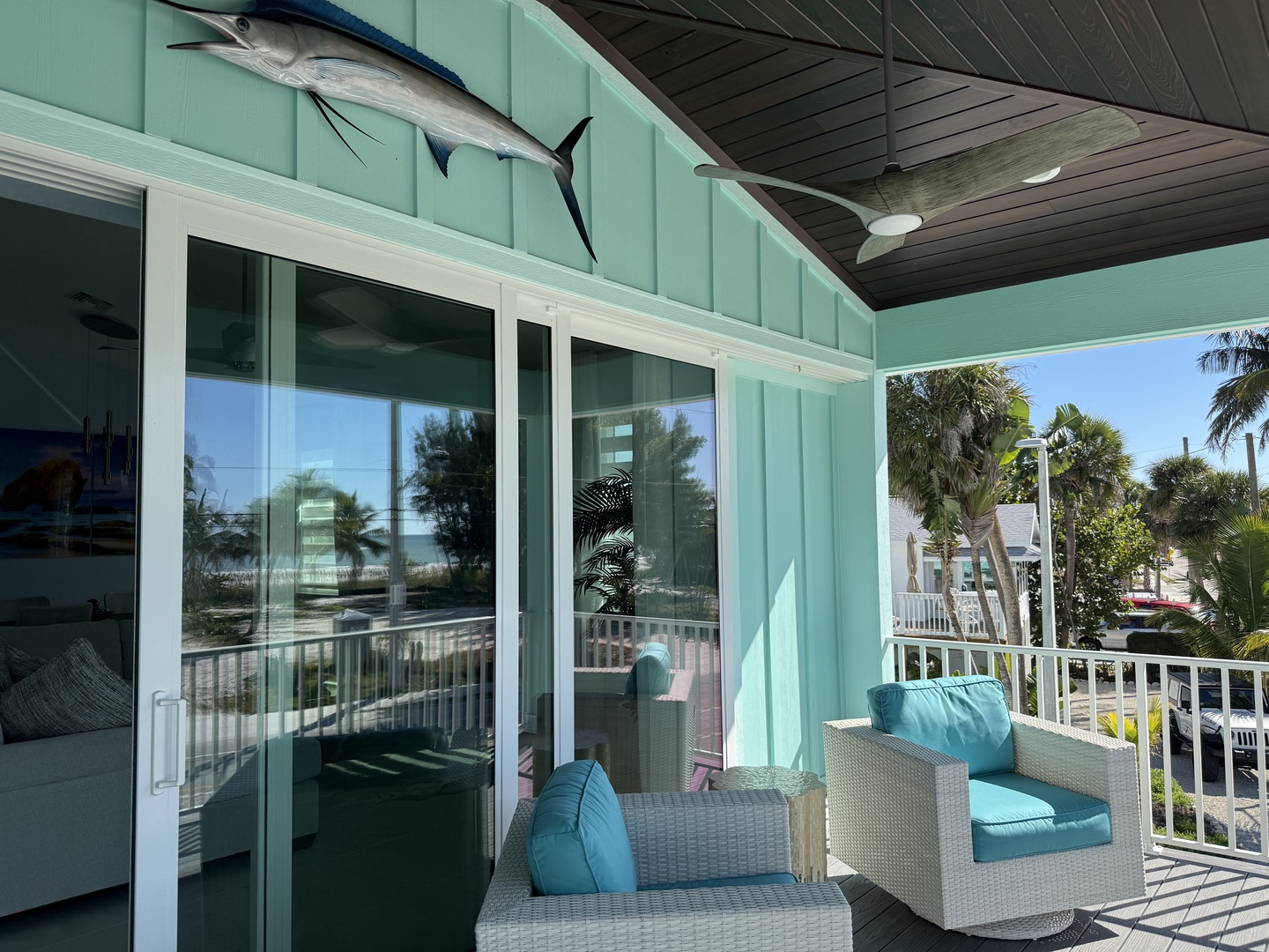 Relax in coastal comfort on your private balcony, where teal cushions and tropical breezes create the perfect oceanside retreat.