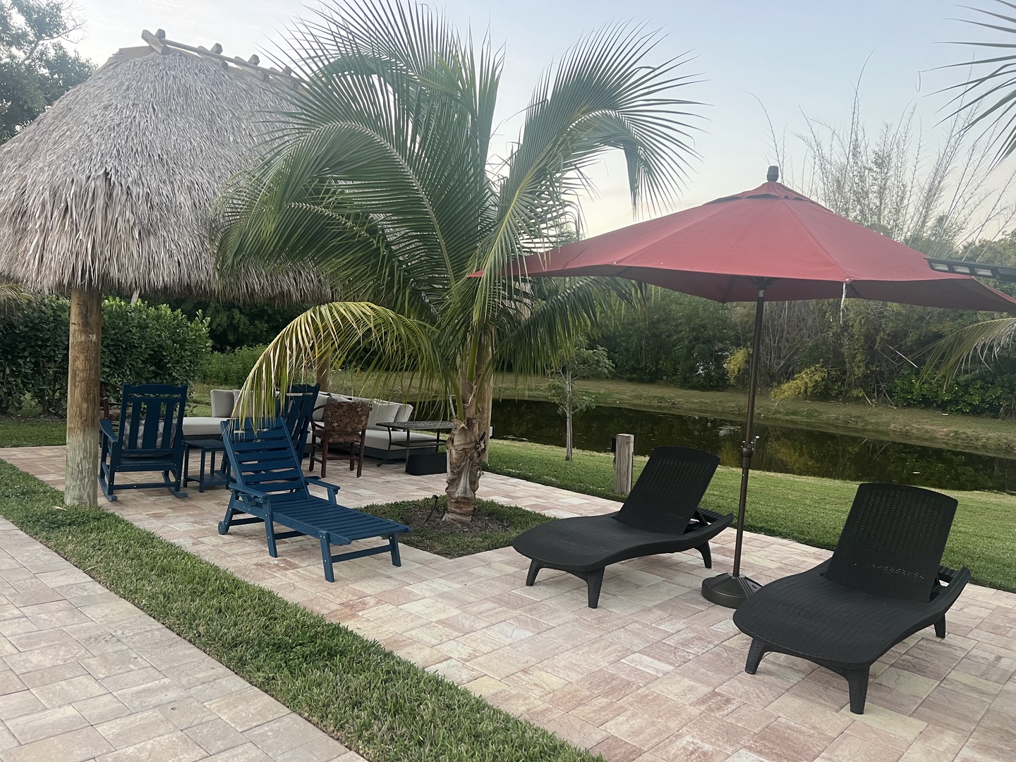 Relax under swaying palms on your private patio, where tropical loungers and waterside seating create the perfect escape.