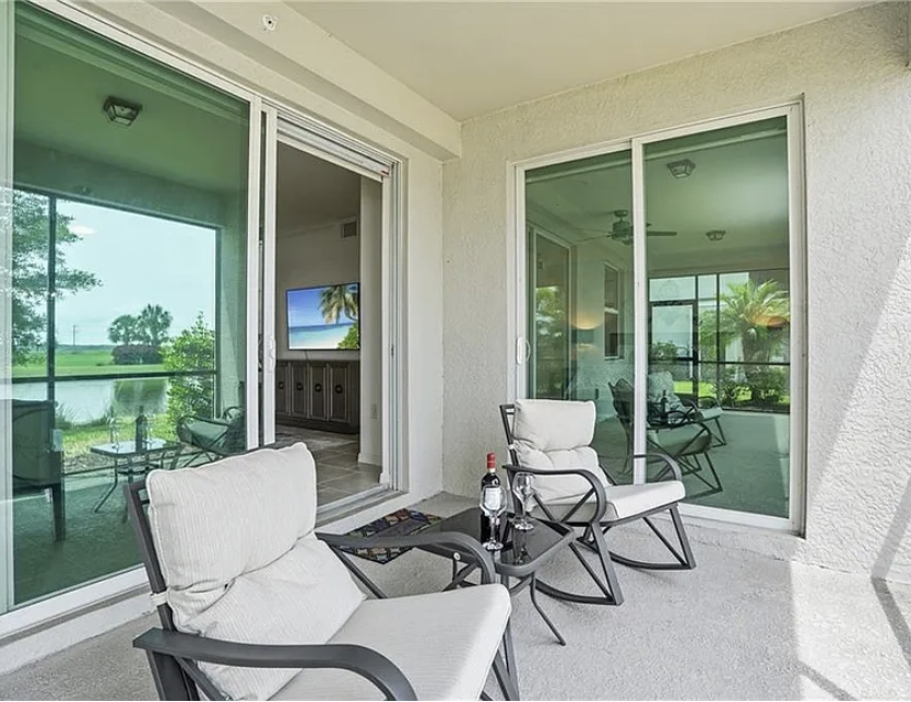 Unwind on your private screened balcony with cushioned seating, where you can sip morning coffee or enjoy evening relaxation while taking in the peaceful golf course views stretching beyond the greenery.