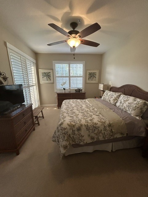 Relax in your peaceful bedroom with a ceiling fan overhead, plantation shutters for gentle light, and tropical décor that sets a breezy, coastal vibe for your getaway.