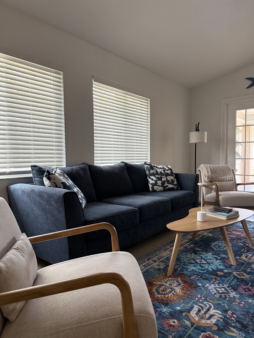 Unwind in your stylish living space with plush seating, beautiful tapestry accents, and natural light streaming through charming windows.