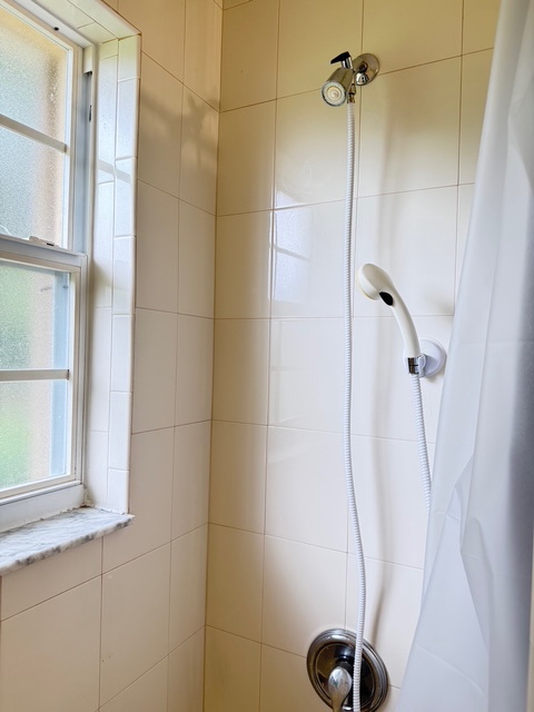Second Bathroom Shower set up Step into your private tiled shower with handheld option and natural window light for a refreshing start to your day.