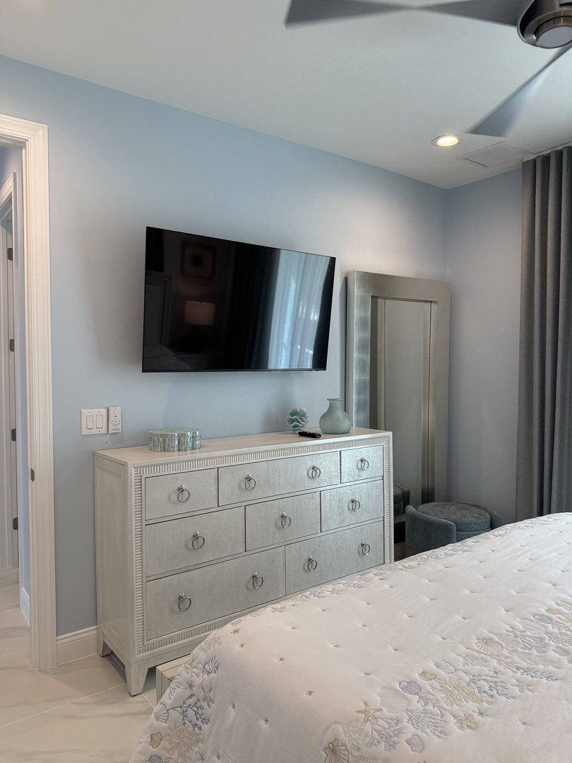 Relax in your elegantly furnished bedroom with ample storage in the beautiful white dresser and enjoy entertainment on the mounted flat-screen TV.