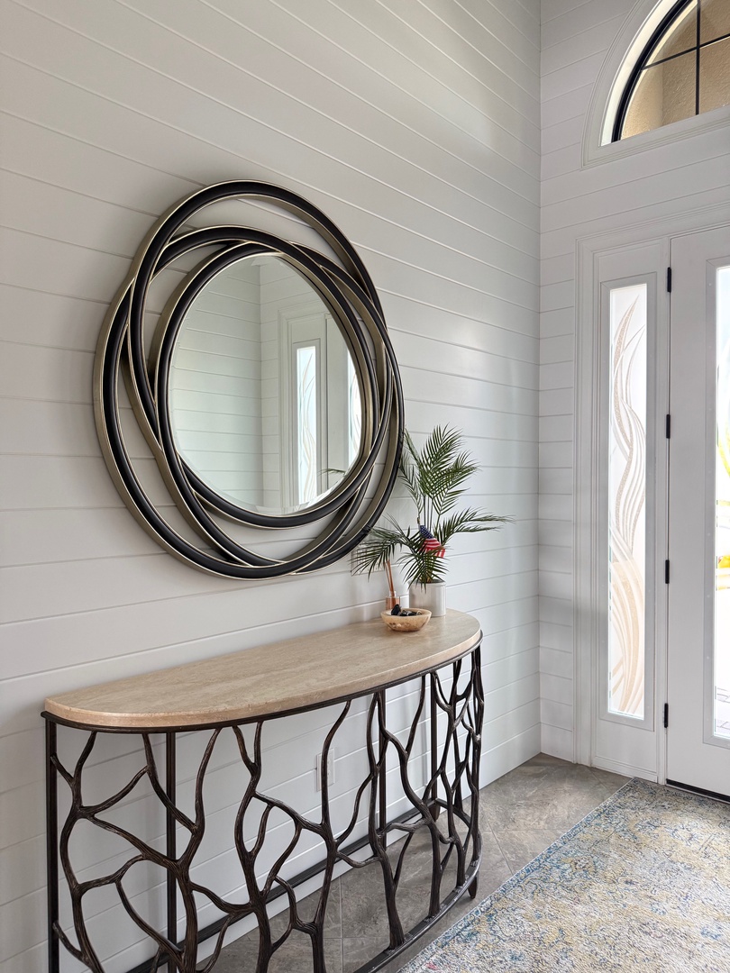 Step into your elegant entrance featuring stunning artistic mirrors and natural light streaming through decorative windows, creating a warm welcome home.