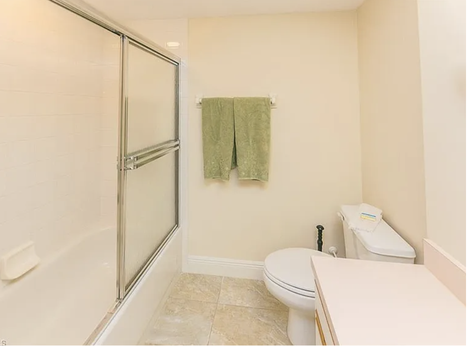 A bright, spotless bathroom awaits you, with soft towels ready and a spacious walk-in shower to refresh after your day of exploring.
