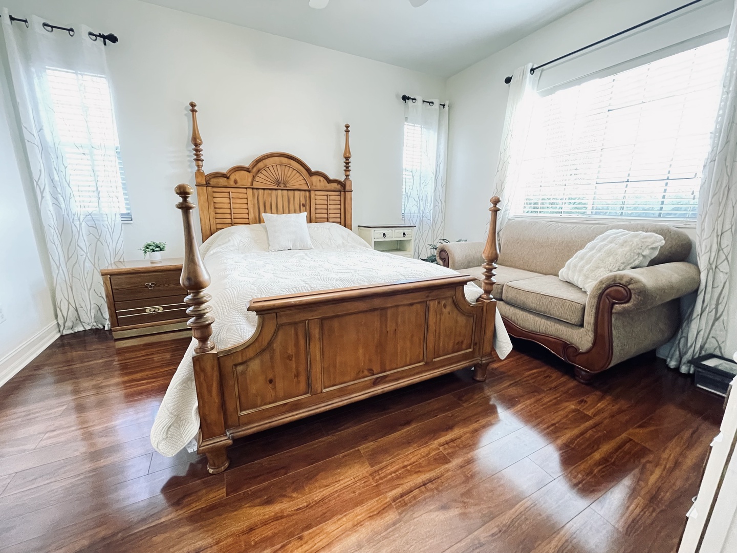 Main King Bedroom 1 Four-poster bed with crisp white linens, then relax in your cozy reading chair by the bright windows.